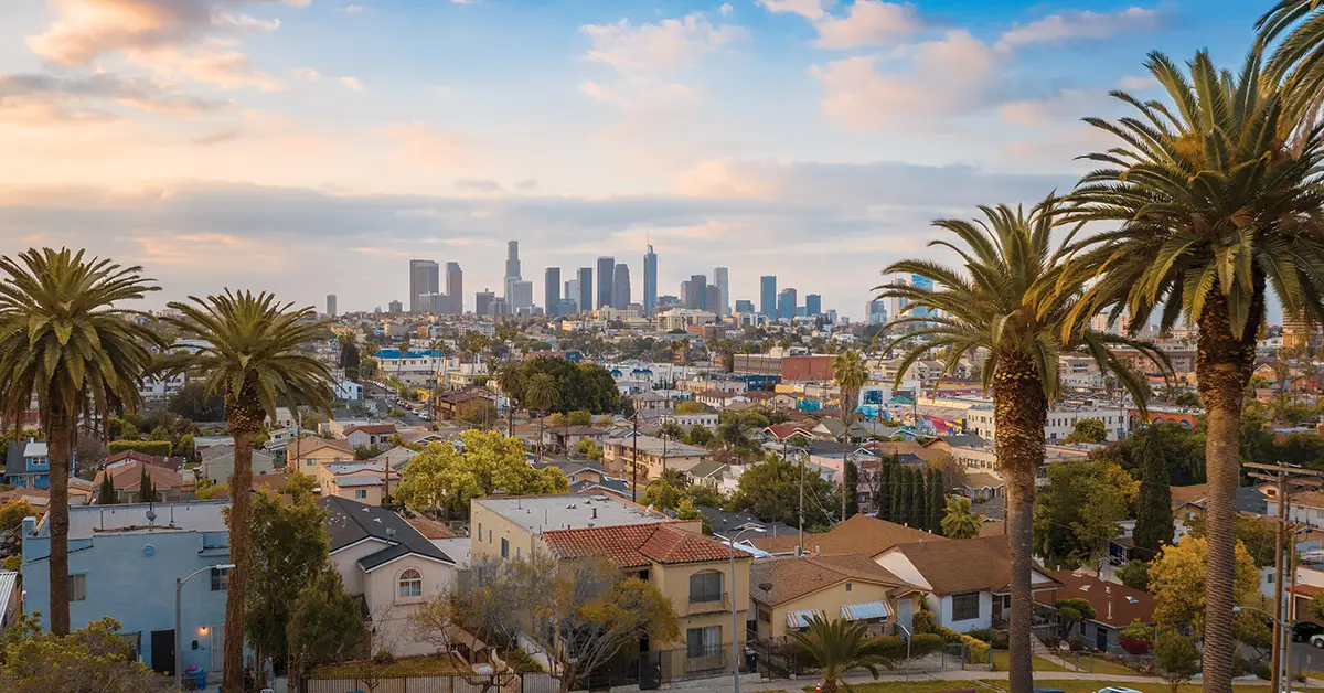 Photo of the Los Angeles, CA skyline, as viewed from a neighborhood. Photo by Adobe Stock
