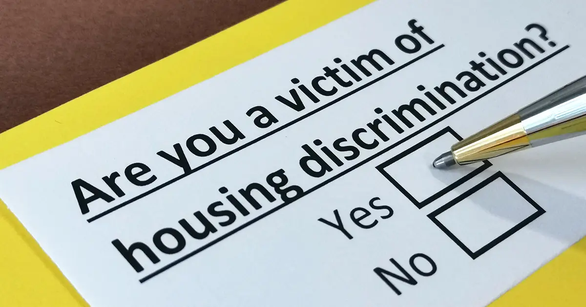 Photo of a form that asks "Are you a victim of housing discrimination?" with a pen hovering over the "Yes" option. Photo By Richelle - Adobe Stock