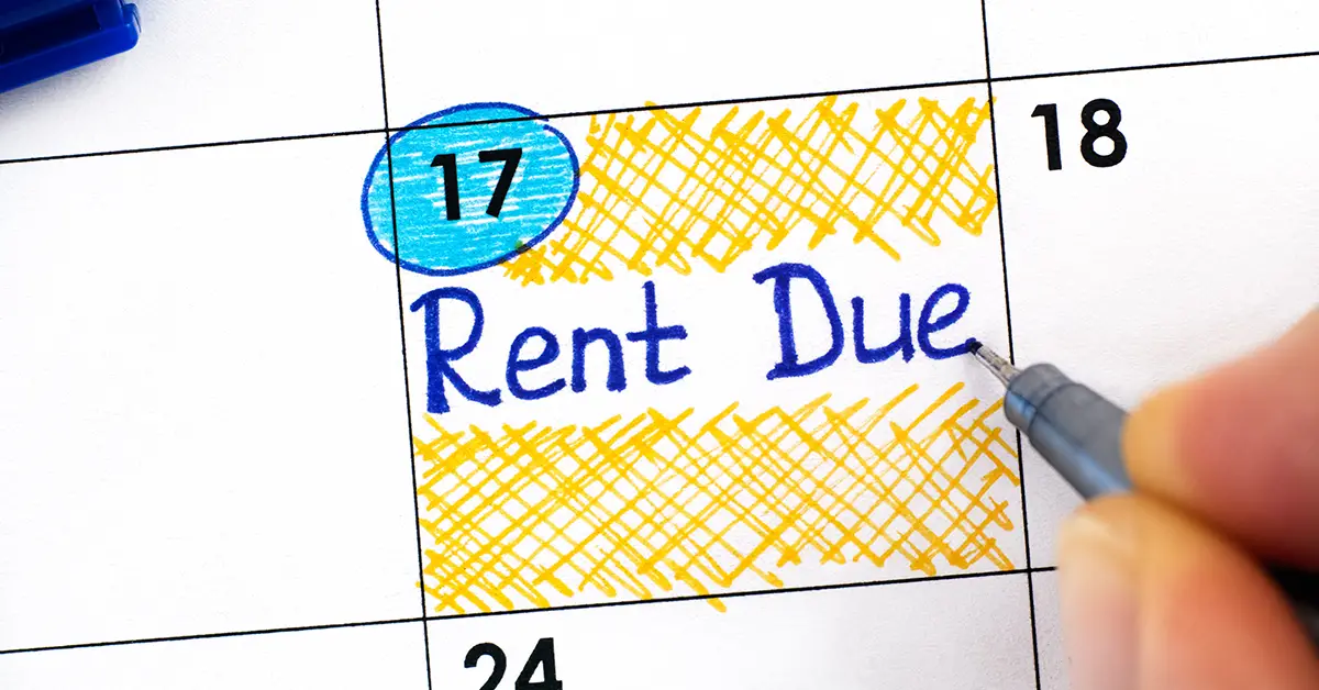 Photo closeup of a person writing "Rent Due" on their monthly calendar.