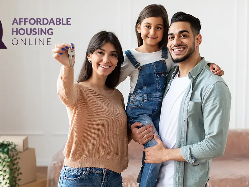 Section 8 Waiting List Announcements Banner image for the week of June 5, 2023 - Affordable Housing Online. Photo of a family of a mom, dad and child smiling while standing in a living room while the mom holds up house keys, with the Affordable Housing Online logo.
